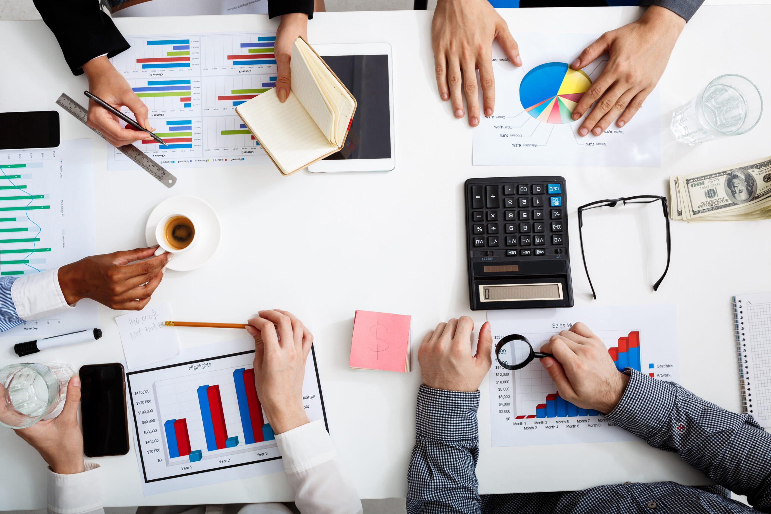 picture of businessmen's hands on white table with documents and drafts